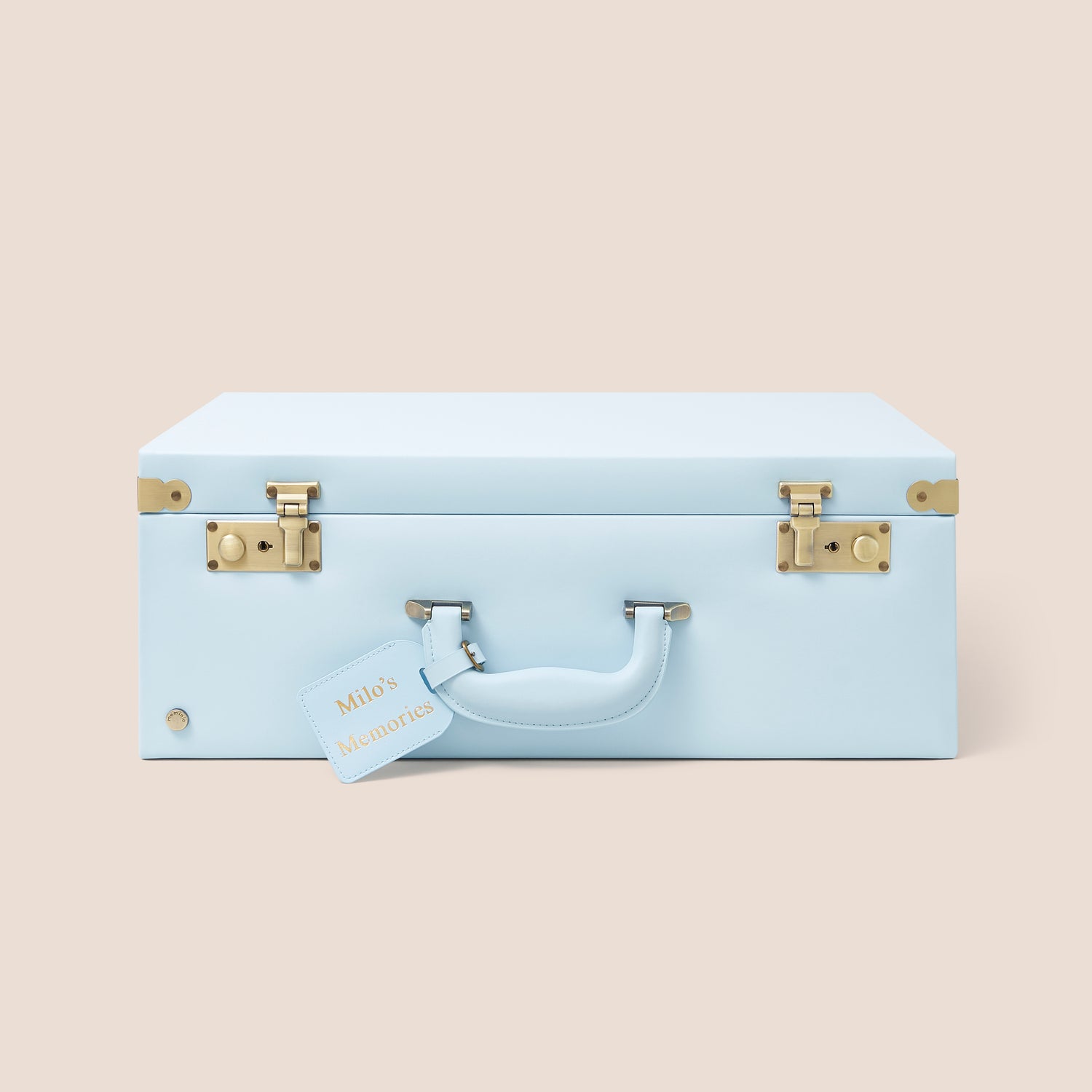 Light blue suitcase with gold accents on a beige background