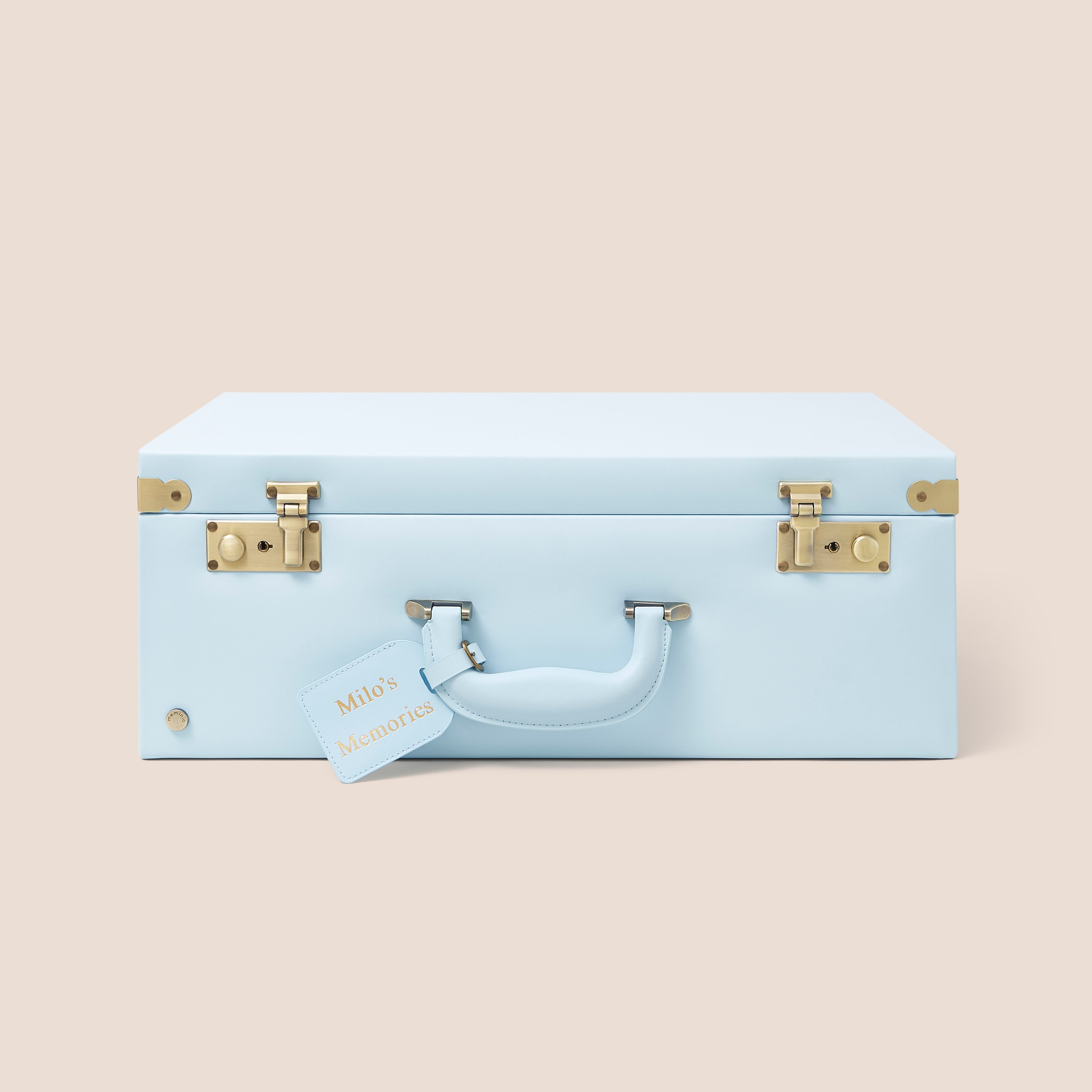 Light blue suitcase with gold accents on a beige background